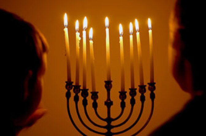 Children gather to see a lighted menorah in celebration of Hanukkah.