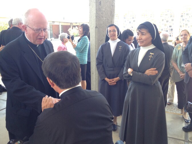 Bishop Kevin Vann shakes the hands of Orange County priests and nuns, including Sister Berta Rafael (right).