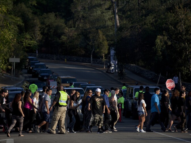 Fans block traffic as they walk to the Rose Bowl for the Eminem and Rihanna concert.