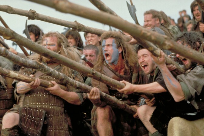 A color picture of Mel Gibson as William Wallace alongside other 13th century fighters from a battle scene in 1995's "Braveheart."