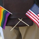 A gay pride and an American flag hang from a shoulder bag during a demonstration outside of the Phillip Burton Federal Building on June 13, 2011 in San Francisco.
