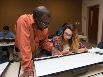 Professor David Thomas helps a student in a Fullerton College architecture class. The college has changed policies to enroll more high school students throughout the year.  
