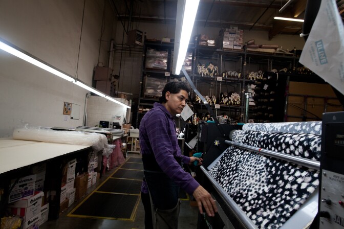 Jose Luis Garcia inspects for variations and holes in fabric before it's sent to production.