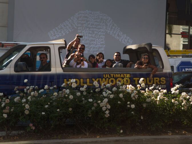 A tour bus stops to take photos of the fake celebrities on Rodeo Drive.