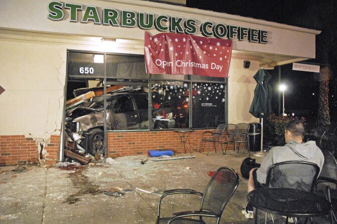 In this photo taken Tuesday, Dec. 13, 2011, an SUV remains in the store after crashing through the wall of a Starbucks in Fillmore, Calif., killing a 30-year-old-man. Ventura County Sheriff's Deputy Jerry Peterson said the SUV, driven by Michael Cedarland, broke through a wall of the coffee shop at about 7 p.m., pinning customer Sergio Mendez against a door frame. Mendez died later at a hospital.