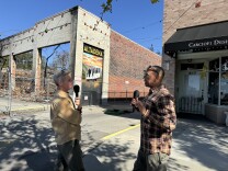 Two men speak into microphones outdoors in Altadena, California. 