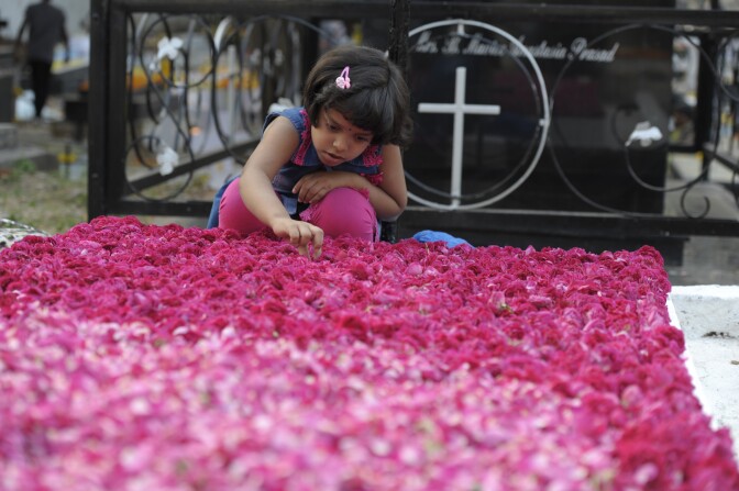 An Indian Catholic girl decorates the grave of a deceased family member at a cemetery during All Souls Day in Hyderabad on November 2, 2016.