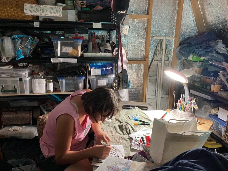 A woman works on crafts while sitting at a table.