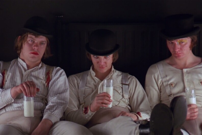 A film still of three characters in "A Clockwork Orange," all holding glasses of milk.