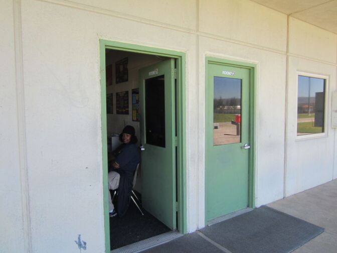 A probation officer sits inside the doorway of a classroom keeping an eye on students in class at Challenger youth probation camp.