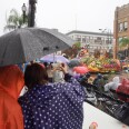 The rainy scene at the Rose Parade on Thursday: Onlookers are huddled beneath umbrellas and most are wearing rain slickers and rain ponchos as they enjoy the floats driving by at the parade. 