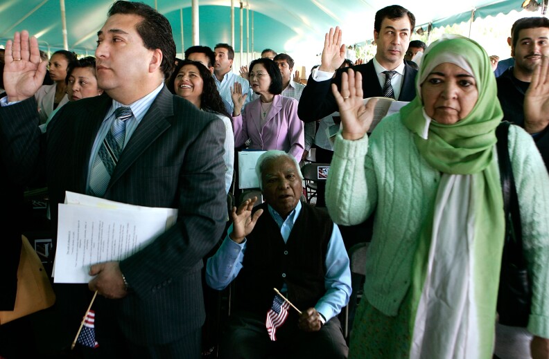Immigrants are sworn in as citizens during a ceremony May 21, 2007 at George Washington’s Mount Vernon Estate and Gardens in Mount Vernon, Virginia. The Senate today began debate on a compromise immigration reform bill which allows illegal immigrants to obtain a renewable “Z visa” after paying a fine, after which they'd be able to get on track toward permanent residency. 