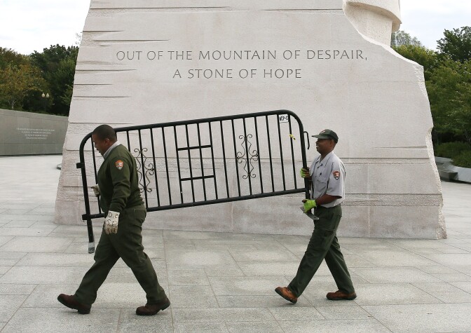 WASHINGTON, DC - OCTOBER 17:  U.S. Park Service workers carry a barricade that was used to close the Martin Luther King Memorial on the morning after a bipartisan bill was passed by the House and the Senate to reopen the government and raise the debt limit, on October 17, 2013 in Washington, DC. President Obama signed the bill into law, that will fund the government until January 15, 2014 and allow the government to pay bills until February 7, 2014.  (Photo by Mark Wilson/Getty Images)