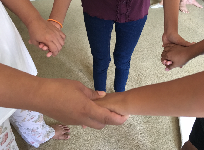 Irma, left, a migrant mother from Guatemala, holds hands with her young daughter and son in her sister's Reseda apartment in late July. The family is together again after having been separated by border officials in May, with Irma placed in immigrant detention and the kids sent to a federal shelter. 
