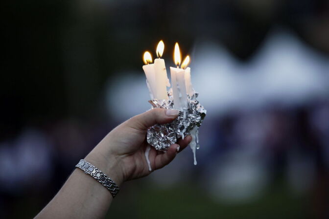 A woman holds candles during a memorial service outside the Aurora Municipal Center July 22, 2012 in Aurora, Colorado. The memorial was for the victims that were killed and wounded during the mass shooting at a movie theater last Friday. James Eagan Holmes, 24, is accused of killing 12 people at a screening of the new "Batman" film.