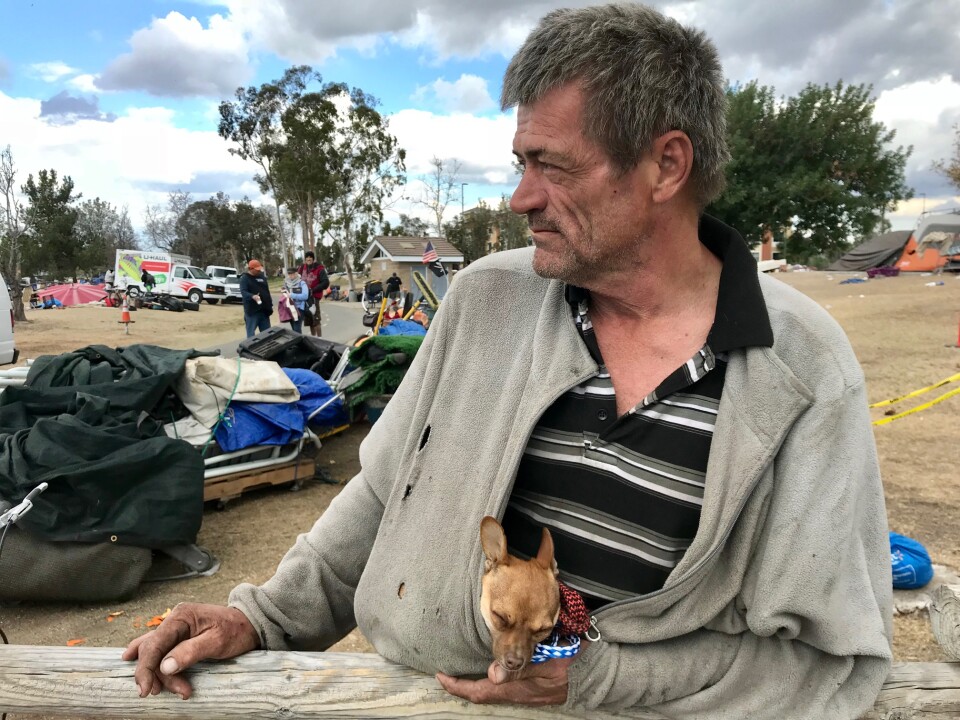 Fritz Reichenbach waits along the Santa Ana River to board a van for a motel in Buena Park where he'll stay for 30 days. 