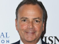 Headshot of Rick Caruso. He's smiling and wearing a white shirt and dark jacket. He has short dark gray hair and a light complexion.