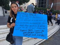 DACA recipient Erika Ramirez holds a sign showing what she accomplished by being allowed to stay in the U.S. at a CHIRLA rally in Downtown Los Angeles on Sept. 1, 2017. She is a 31-year-old social worker who drove out from Hemet to attend the rally.