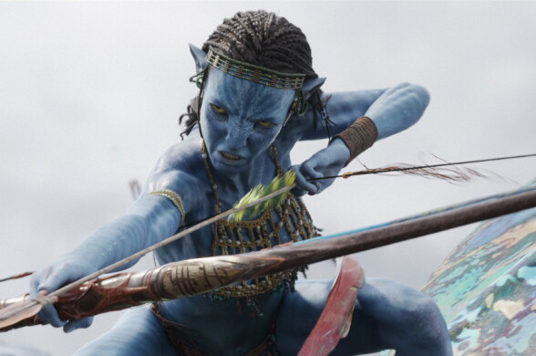 An blue Avatar character has cornrow braids and is wielding a bow and arrow, poised to shoot. \