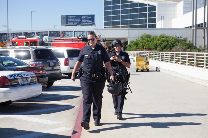 Police officers Leslie Perkins and Fredy Lazlo leave the scene at LAX on November 1st, 2013.
