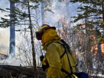 A Riverside City firefighter monitors a burnout operation along Jenks Lake Road Thursday afternoon at the Lake Fire. 
