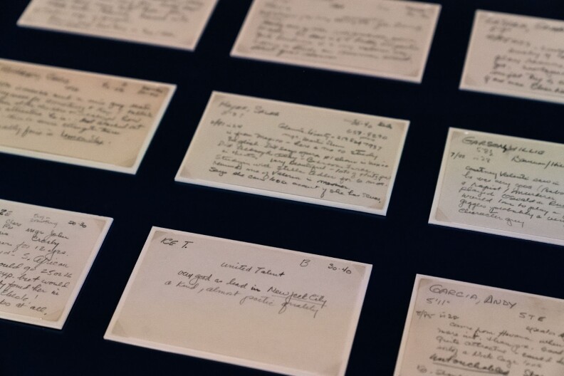 A white 3 by 5 index card in a museum gallery case, in a row with several other cards on a black background, with casting director Marion Dougherty's hand-written notes about her impressions of rapper/actor Ice T. It reads “Very good as lead in ‘New Jack City.” A kind, almost poetic quality.”