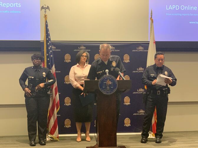LAPD Chief Michel Moore (center) speaks to media about the department's new ability to file traffic reports online. 