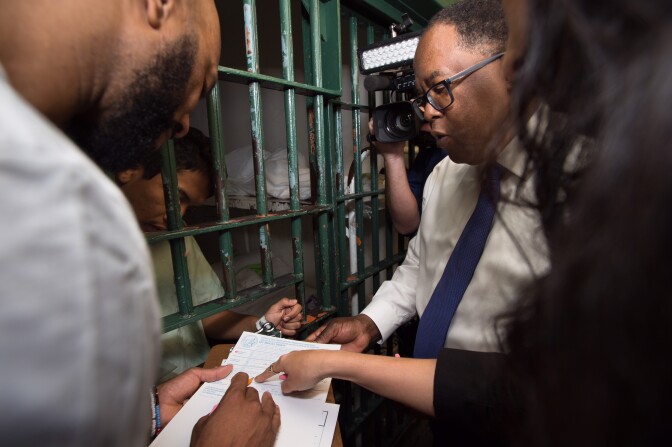 Rapper Common and Supervisor Mark Ridley-Thomas help an inmate at LA County Men's Central Jail register to vote. Photo courtesy of Bryan Chan / Los Angeles County Board of Supervisors.