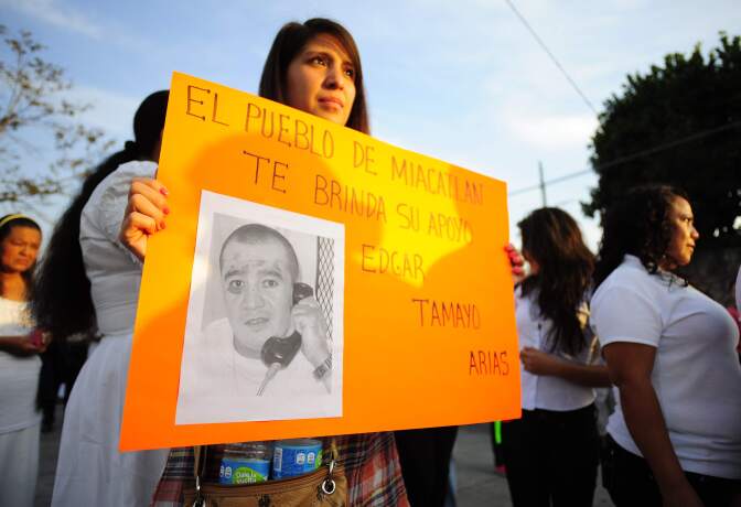 In this Jan. 19, 2014 photo, a woman holds up a sign showing a photo of Texas death-row inmate Edgar Tamayo that reads in Spanish "The town of Miacatlan offers you our support, Edgar Tamayo Arias" during a protest demanding Tamayo's pardon in his hometown of Miacatlan, Mexico.   