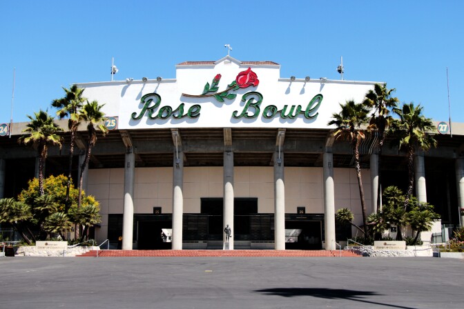 The Rose Bowl stadium with its signage displaying its name on a white background and a red rose in the center.