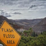 File: In this photo provided by Santa Barbara County Fire Department, a flash flood area sign is posted, as evacuations have been issued for several fire-ravaged communities in Santa Barbara, Monday, Jan. 8, 2018.