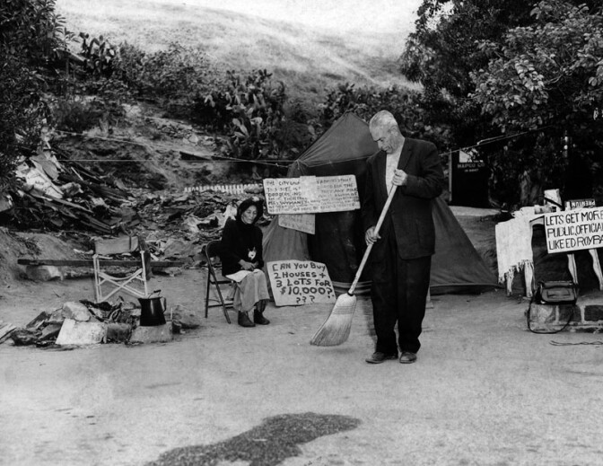 May 16, 1959: "All was quiet on the Chavez Ravine battlefront. Avrana and Manuel Arechiga are the only remaining eviction warriors there. He's sweeping the dirt off the 'front porch' of their tent. Protest signs are posted nearby." Courtesy of the Los Angeles Public Library
