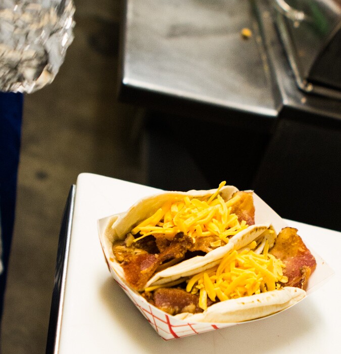 Breakfast tacos full of cheese, eggs, bacon and beans in flour tortillas at Joe's Bakery in Austin, Texas.