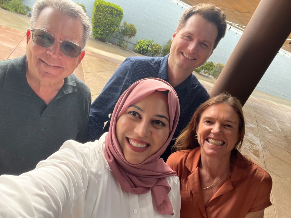LAist staff members Ted Rohrlich, Nick Gerda, Jill Replogle and Yusra Farzan smile and stand close together for a selfie.