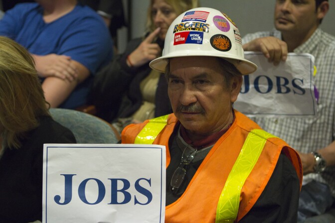 Armando Sainez holds up a sign in support of starting work on the subway extension.