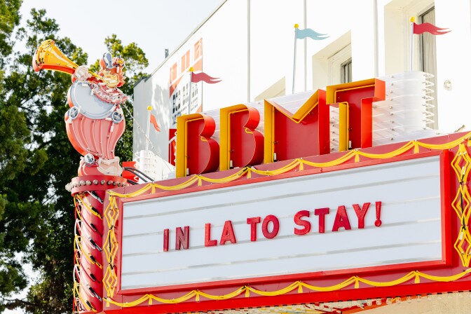 A neon theater marquee that say "IN LA TO STAY!"