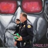 MIAMI, FL - AUGUST 02:  James Bernat and Michelle Albelo, City of Miami police officers, give out cans of insect repellent as they help people near the Miami Rescue Mission prevent mosquito bites that may infect them with the Zika virus on August 2, 2016 in Miami, Florida.  A reported 14 individuals have been infected with the Zika virus by local mosquitoes.  (Photo by Joe Raedle/Getty Images)