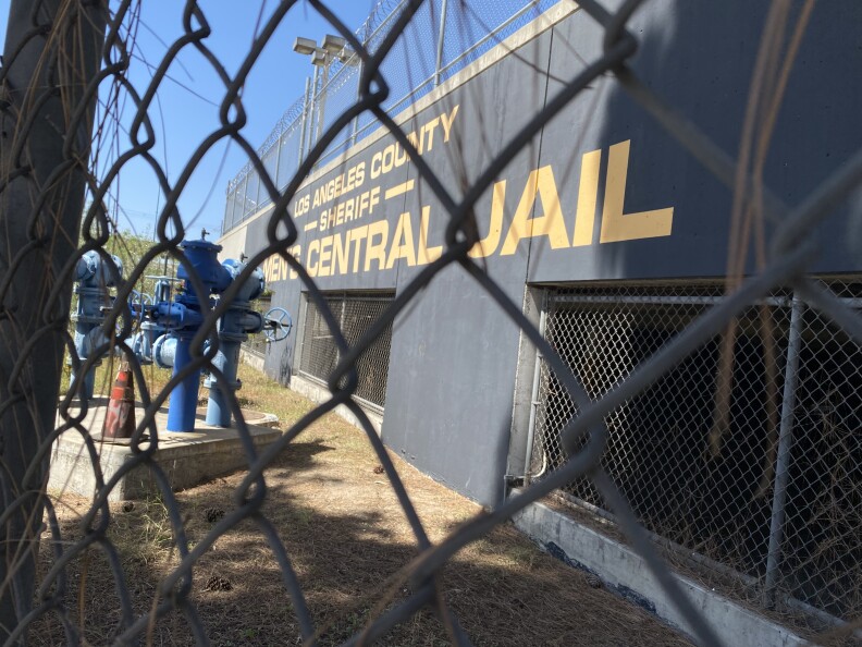 Signage for Men's Central Jail can be seen through a chainlink fence