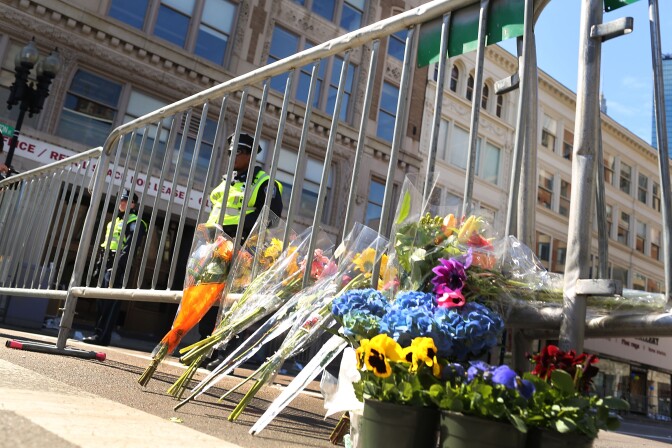 BOSTON, MA - APRIL 16:  Flowers are left at a security gate near the scene of yesterday's bombing attack at the Boston Marathon on April 16, 2013 in Boston, Massachusetts. The twin bombings, which occurred near the marathon finish line, resulted in the deaths of three people while hospitalizing at least 128. The bombings at the 116-year-old Boston race, resulted in heightened security across the nation with cancellations of many professional sporting events as authorities search for a motive to the violence.  (Photo by Spencer Platt/Getty Images)