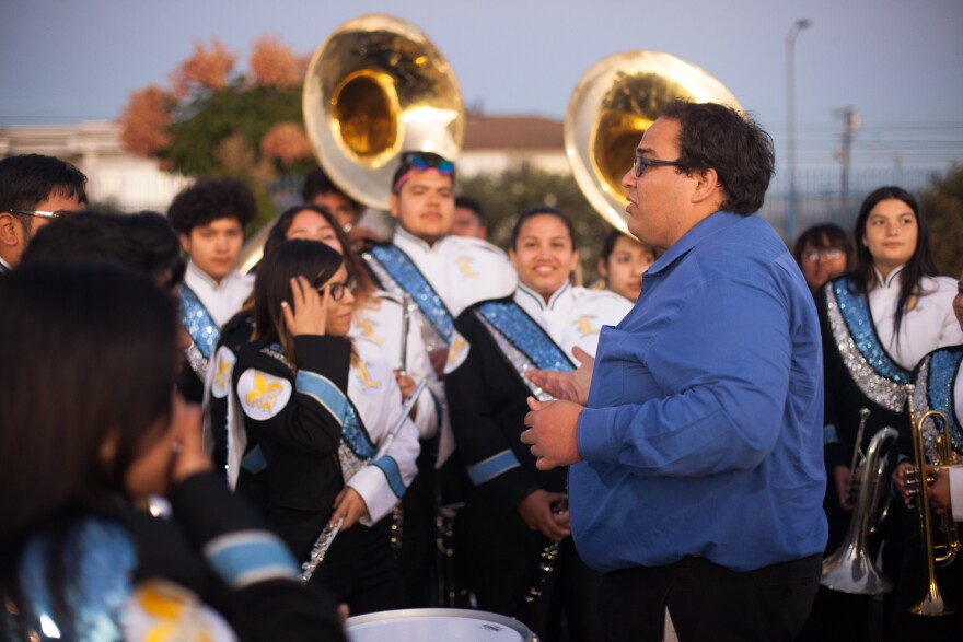 Band co-director Matthew Stickman speaks to band members at the Locke High School homecoming game.