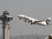 LOS ANGELES, CA - APRIL 22:  An Alaska Airlines jet passes the air traffic control tower at Los Angles International Airport (LAX) during take-off on April 22, 2013 in Los Angeles, California. Delays have been reported throughout the nation because of the furloughing of air traffic controllers under sequestration. The average delay overnight in the Southern California Terminal Radius Approach Control (TRACON) was was three hours.  (Photo by David McNew/Getty Images)