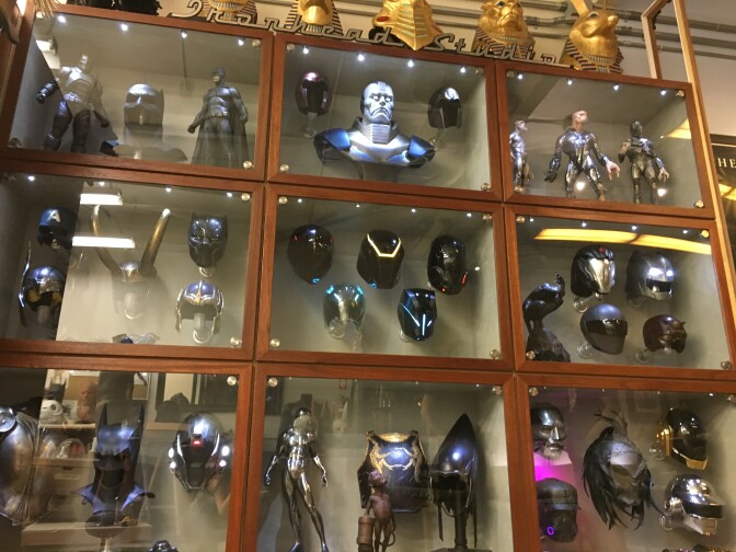 Ironhead Studio Display Case includes superhero headpieces,  DJ helmets, and action figures.