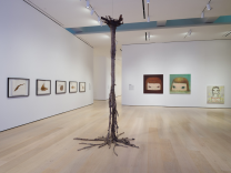 A bright room with light wood floors. Artwork hangs on the walls