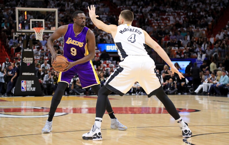 MIAMI, FL - DECEMBER 22: Luol Deng #9 of the Los Angeles Lakers passes around Josh McRoberts #4 of the Miami Heat during a game  at American Airlines Arena on December 22, 2016 in Miami, Florida. NOTE TO USER: User expressly acknowledges and agrees that, by downloading and or using this photograph, User is consenting to the terms and conditions of the Getty Images License Agreement.  (Photo by Mike Ehrmann/Getty Images)
