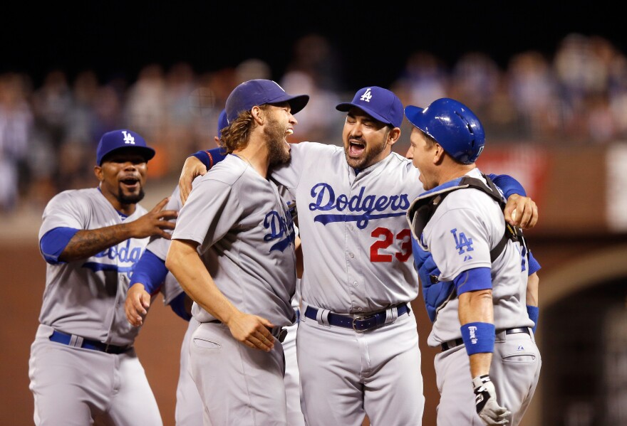 SAN FRANCISCO, CA - SEPTEMBER 29:  (L-R)  Clayton Kershaw #22, Adrian Gonzalez #23 and A.J. Ellis #17 of the Los Angeles Dodgers celebrate after they beat the San Francisco Giants to clinch the National League West title at AT&T Park on September 29, 2015 in San Francisco, California.  (Photo by Ezra Shaw/Getty Images)