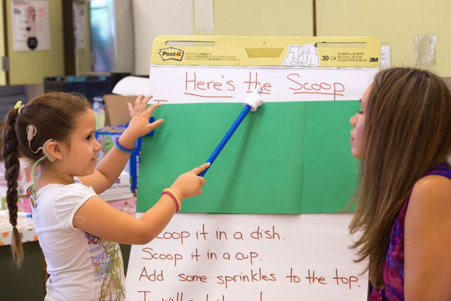 Yurianna Lara, 6, works with deaf and hard-of-hearing teacher Ann Franklin, right, during a shared reading exercise as part of the innovative "Come Read With Me" USC Program that helps develop literacy for deaf and hard of hearing children from bilingual families, July 21, 2016. (USC Photo/Gus Ruelas)