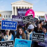 Pro-choice activists hold signs in response to anti-abortion activists participating in the "March for Life," an annual event to mark the anniversary of the 1973 Supreme Court case Roe v. Wade, which legalized abortion in the US, outside the US Supreme Court in Washington, DC, January 18, 2019. (Photo by SAUL LOEB / AFP)        (Photo credit should read SAUL LOEB/AFP/Getty Images)