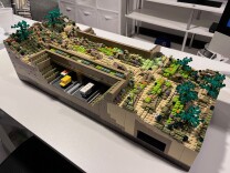 A toy set of a bridge made up of different Lego tiles in earth tone colors