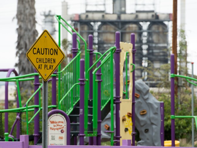 An oil refinery and highway are visible over the fence of a Long Beach child care center. KPCC reporters Deepa Fernandes and Sarah Monte investigate the effect of air pollution on early childhood development by taking air quality readings outside of child care centers located in Los Angeles County.