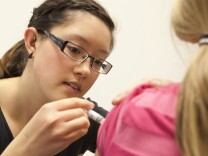 A nursing student gives a young girl a flu shot. Should non-vaccinating parents be liable if other children get sick?